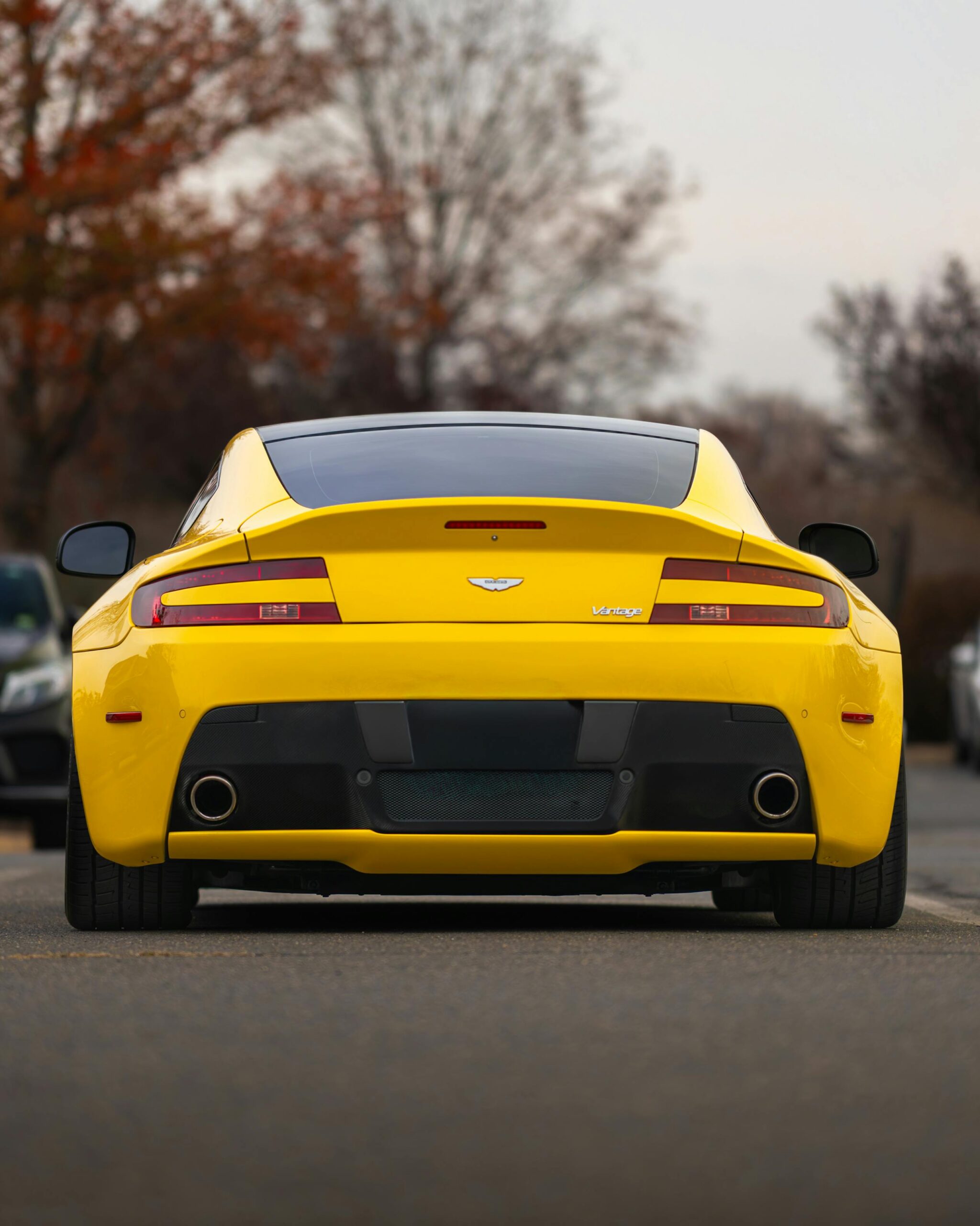 Captivating rear view of a yellow luxury sports car parked on an autumn street in Ashburn.